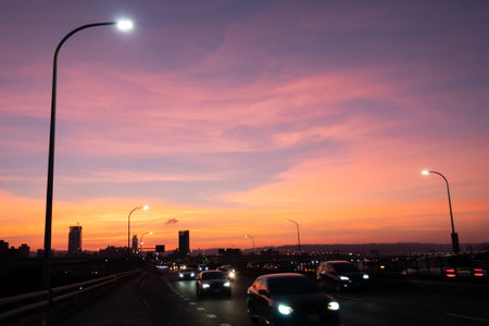 Taipei, Taiwan-Oct 2nd, 2020: sunset cityscape with silhouette of cars and buildings under dramatic...