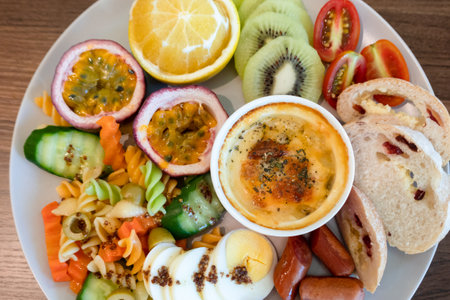 breakfast of bread, vegetables and fruits on a dish in the morningの写真素材