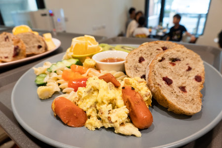 breakfast of bread, vegetables and fruits on a dish in the morningの写真素材
