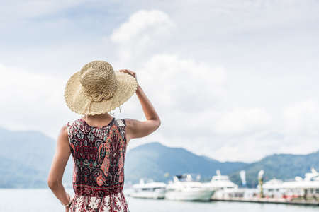 traveling Asian woman with hat standing at Sun Moon Lake, Taiwanの写真素材