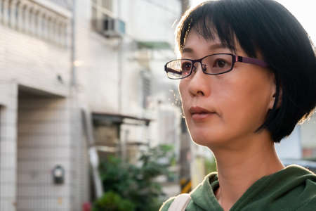 attractive mature Asian woman portrait stand at the street in the cityの写真素材