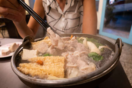 Taiwanese small hot pot with vegetables and meat at restaurantの写真素材