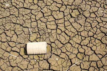 old oil drum on dried crack land during drought with good texture