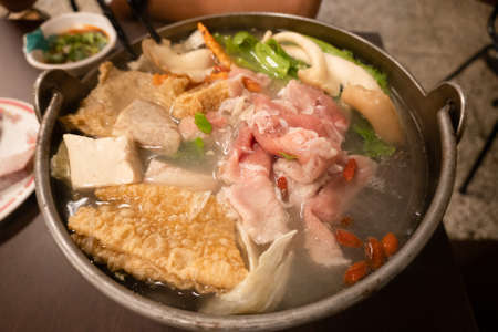 Taiwanese small hot pot with vegetables and meat at restaurantの写真素材