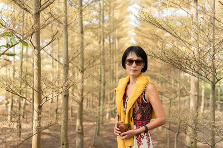 modern Asian woman hold a camera in the forest