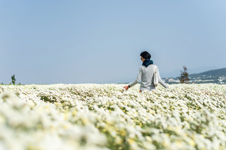 modern Asian woman stand at the white chrysanthemum farm