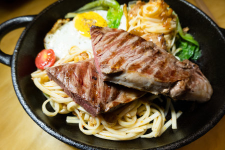 sliced steak with fried noodles on a plate at homeの写真素材