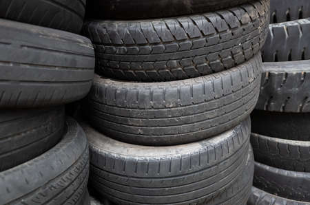 old used car tires stacked in piles in the daytimeの写真素材