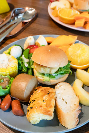 hearty breakfast with bread and fruit on a plate at homeの写真素材