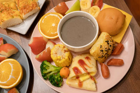 hearty breakfast with bread and fruit on a plate at homeの写真素材