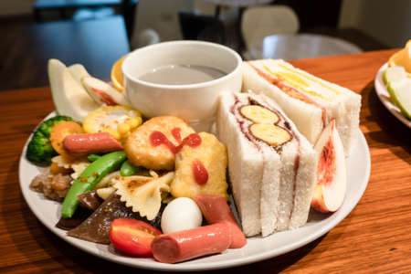 hearty breakfast with bread and fruit on a plate at homeの写真素材