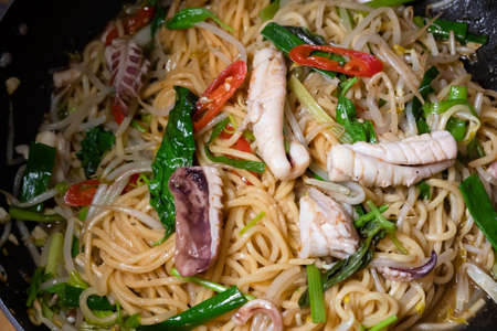 sauteed noodles with squid on a plate at homeの写真素材