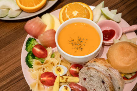 hearty breakfast with bread and fruit on a plate at homeの写真素材