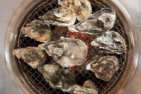 fresh oysters on barbecue grill in a restaurant at Taiwanの写真素材