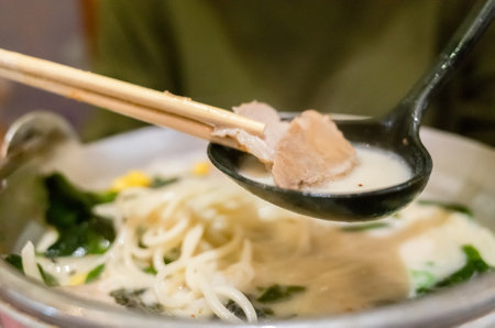 woman eat a bowl of tonkotsu ramen in the restaurantの写真素材
