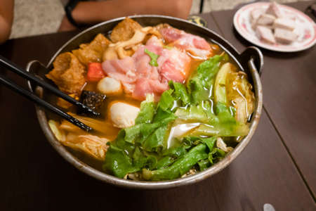 Taiwanese small hot pot with vegetables and meat at restaurantの写真素材