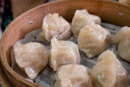 Chinese steamed jiaozi in a bamboo steamer on a table in Taiwanの写真素材
