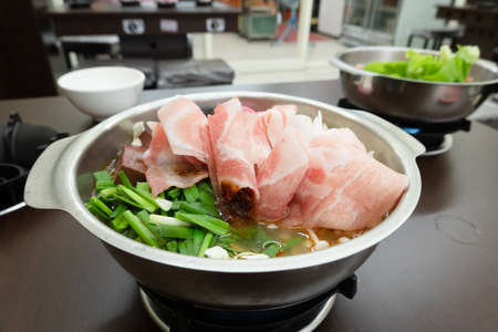 Taiwan hot pot with sliced pork and vegetables at a restaurantの写真素材