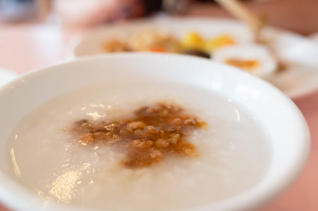 a bowl of white rice porridge with porkの写真素材