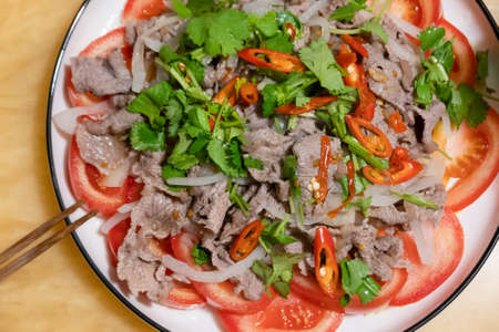 appetizer of pork put on sliced tomatoes and onions in a dishの写真素材