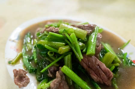 taiwanese snack of beef with water spinach on a plate in a restaurantの写真素材