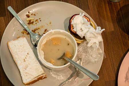 dirty plate and cup with food leftovers on the tableの写真素材