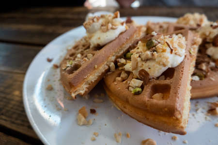 delicious waffle on a dish at wooden deskの写真素材