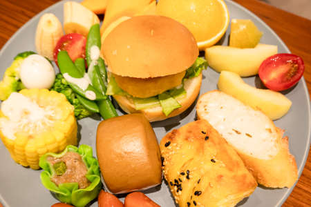hearty breakfast with bread and fruit on a plate at homeの写真素材