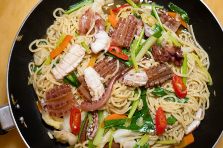 sauteed noodles with squid on a plate at homeの写真素材