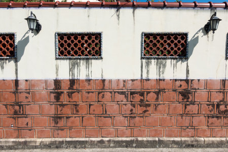 Old Chinese traditional red brick walls with decorative lattice windows.の写真素材