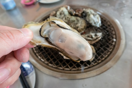 Fresh oysters on barbecue grill in a restaurant at Taiwanの写真素材