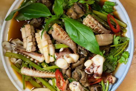 sauteed squid with vegetables in a dish on the tableの写真素材