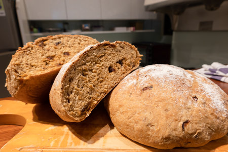 homemade round bread in a wooden plate on the tableの写真素材