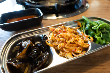 The side dishes at the Korean restaurant include blanched spinach, bean sprouts, and seaweed sproutsの写真素材