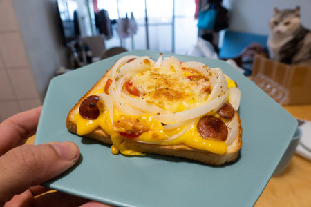 breakfast of homemade toast topped with sausage, cheese, and onions