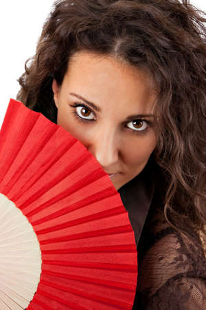 Sexy lady with interesting look behind a red fanの写真素材