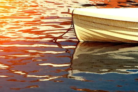 White boat in the water at sunsetの写真素材
