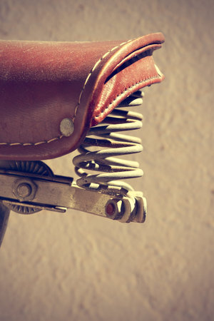 Detail of retro bike saddle. Suspension mechanism have two springs. Vintage style. Vertical image.の写真素材