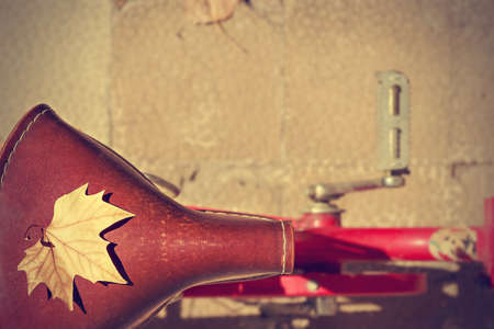 Autumn leaf over the saddle of an old bike. Vintage style. Concept arrival autumn. Horizontal image.の写真素材