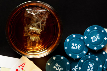 Glass of whiskey with cards and poker chips viewed from above. Horizontal image.