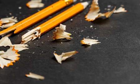 Broken pencil with shavings on black background. Horizontal image.の写真素材
