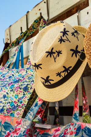 Straw hat with drawings of palm trees in a summer market. Vertical image.の写真素材