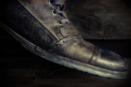 Detail of gray leather casual shoe for man on wooden board. Dark mood style. Horizontal image.の写真素材