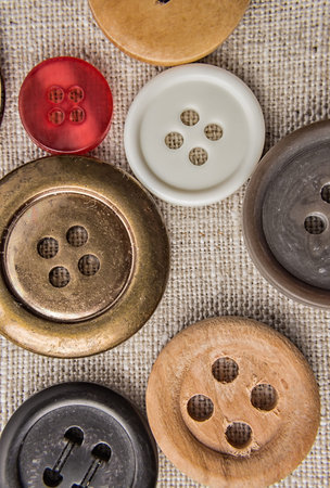 Sewing buttons of various sizes and colors on sackcloth.の写真素材