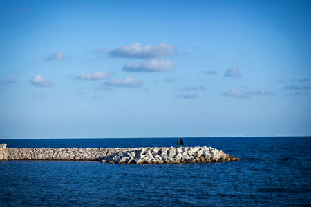 Cement groyne with calm sea and blue sky.の写真素材