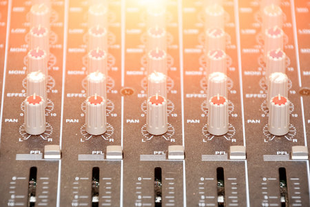 DJ mixer. illuminated from behind by the light of a spotlight.