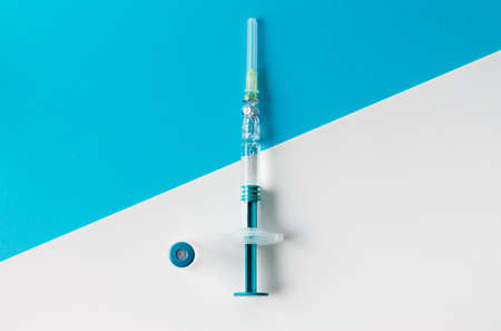 Syringe with medical vial for injection on blue and white background. Top view.の写真素材