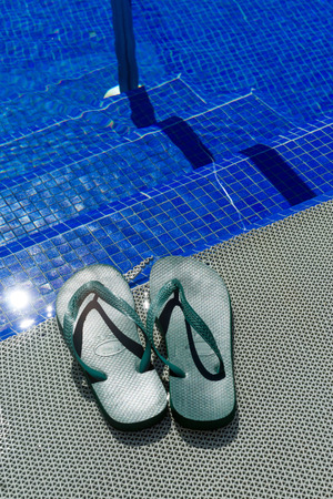 Green flip-flops at a poolの写真素材