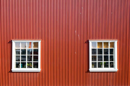 Red wall and two windows seen in Reykjavik, Icleandの写真素材