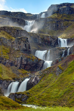 The Klifbrekkufossar waterfall in the Mjoifjordur in Icelndの写真素材